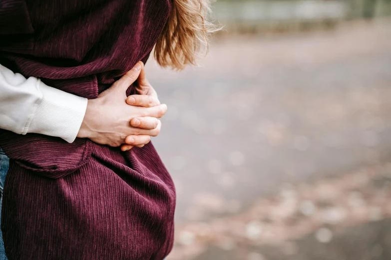 a couple hugging each other on the side of a road, by Emma Andijewska, trending on pexels, renaissance, folds of belly flab, maroon and white, cysts, woman