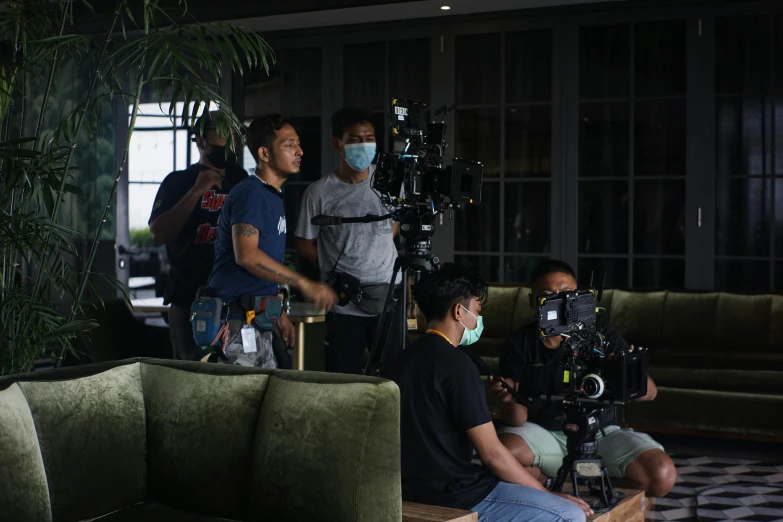 a group of people sitting around a couch in a living room, film production, bali, worksafe. cinematic, disney weta 8 k