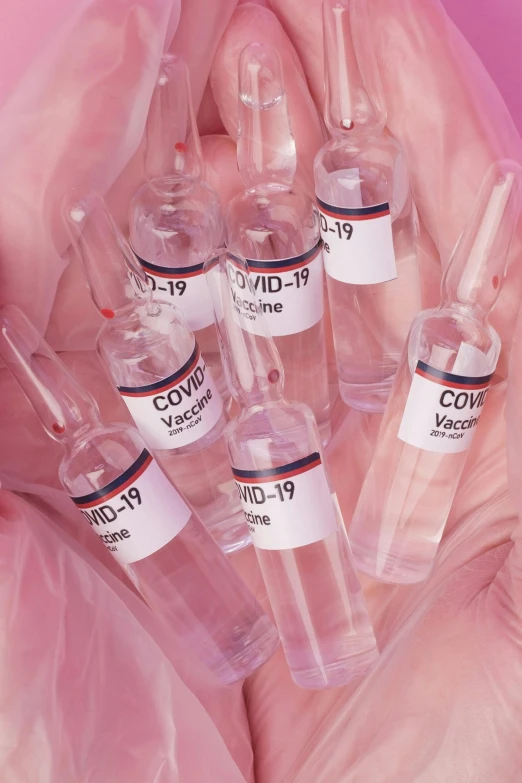 a person holding a bunch of vials in their hands, an album cover, by Eva Frankfurther, trending on pexels, ((pink)), medical labels, fluids, - 12p