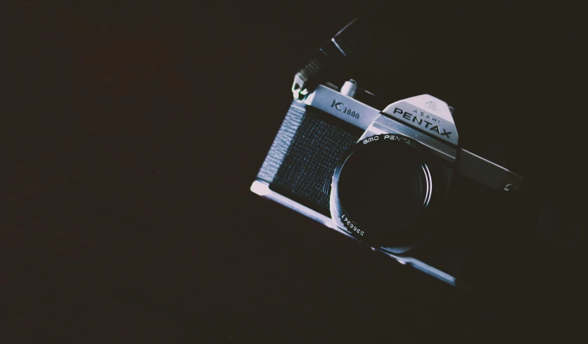 a black and white photo of a camera, inspired by Elsa Bleda, pexels contest winner, on a dark background, color film camera, instagram photo, pentax k-1000