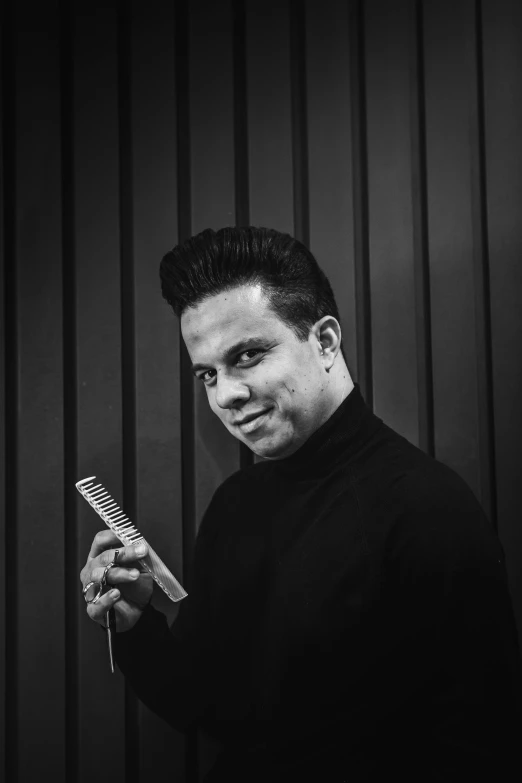 a black and white photo of a man holding a comb, inspired by Eddie Mendoza, pompadour, jack white, looking left, tapered hairline