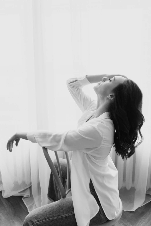 a black and white photo of a woman stretching, wearing a white blouse, song hye - kyo, sitting relax and happy, :: morning