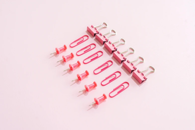 a bunch of pink clips sitting on top of a white surface, pexels, dau-al-set, 8 x, red, 1 0, item