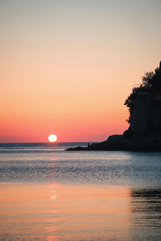 the sun is setting over a body of water, pexels contest winner, romanticism, japan shonan enoshima, ibiza, cliffs, serene colors