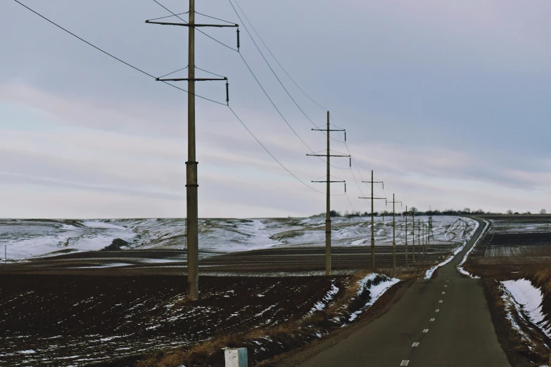 an empty road in the middle of a snowy field, unsplash, hyperrealism, power lines, stacked image, prairie, 2 0 0 0's photo