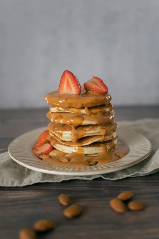a stack of pancakes topped with strawberries and almonds, 6 pack, caramel, blond, 10k