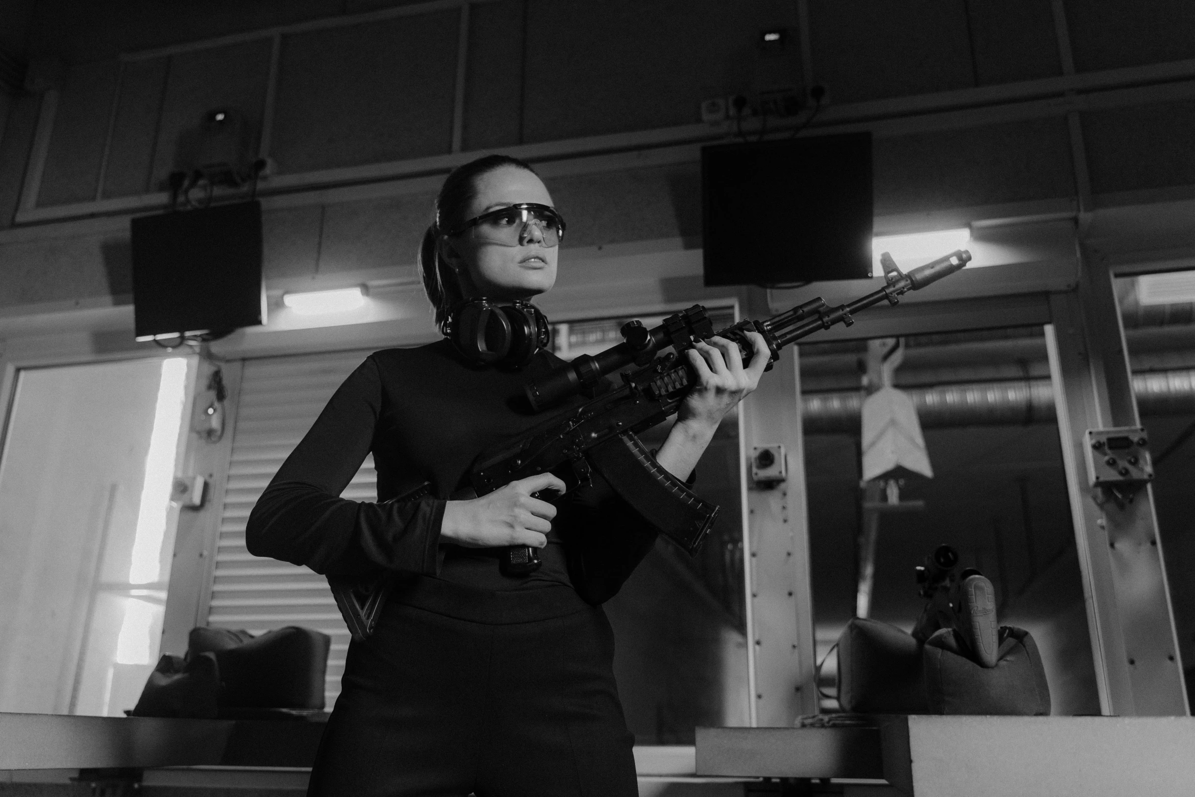 a black and white photo of a woman holding a gun, pexels, cobra, animatronic angelina jolie, in black uniform, cinematic outfit photo, pulse rifles