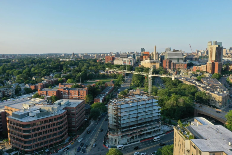 a view of a city from the top of a building, by Washington Allston, unsplash, crane shot, taken in 2022, all buildings on bridge, hospital in background