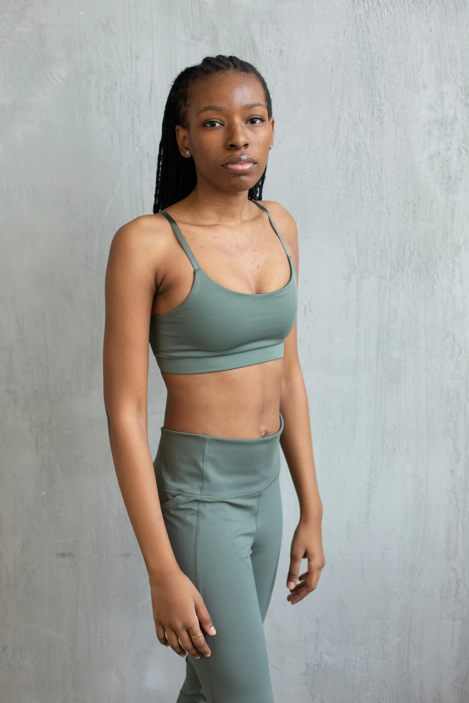 a woman in a green sports bra top and leggings, inspired by Tadashige Ono, muted green, promo image, muted colors. ue 5, dark skinned