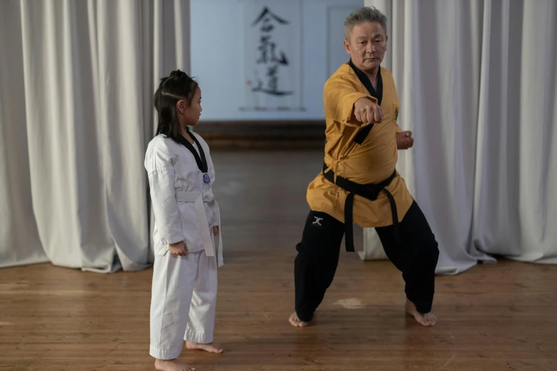 a man standing next to a little girl on a wooden floor, inspired by Liao Chi-chun, grading, grand master, brown, medium-shot