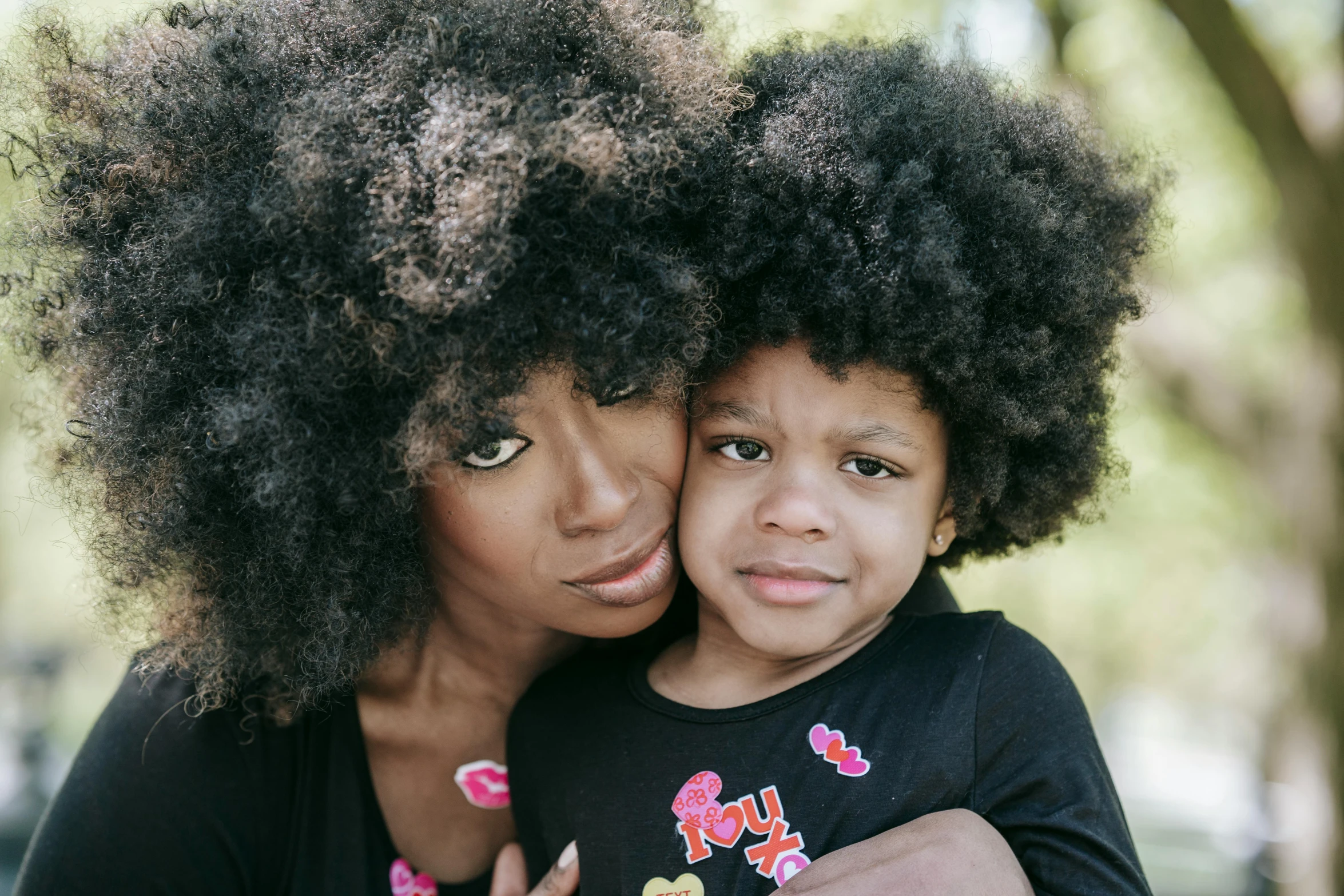 a woman and a child posing for a picture, a portrait, pexels contest winner, afrofuturism, lush unkempt black hair, 4yr old, big hair, family photo