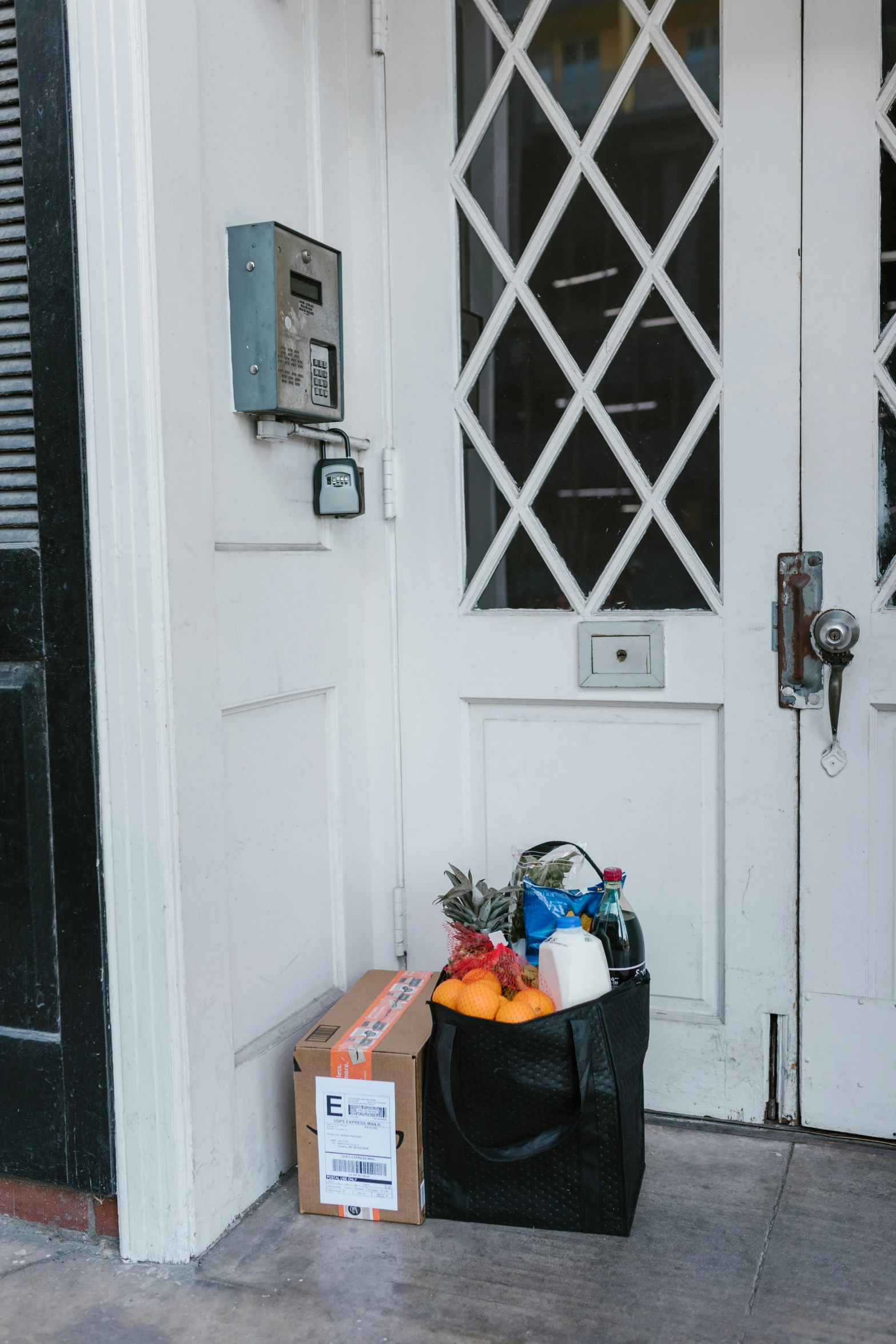 a black bag sitting in front of a white door, a photo, private press, getting groceries, cornucopia, brooklyn, loot box