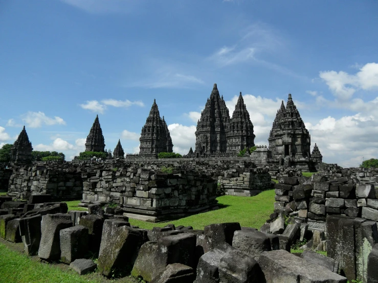 a group of stone structures sitting on top of a lush green field, pexels contest winner, sumatraism, spires, avatar image, square, grey