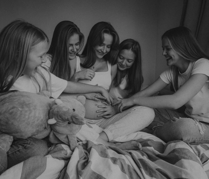 a group of young women sitting on top of a bed, a black and white photo, by Emma Andijewska, pexels contest winner, pregnant belly, cute girls, happy birthday, 🤬 🤮 💕 🎀