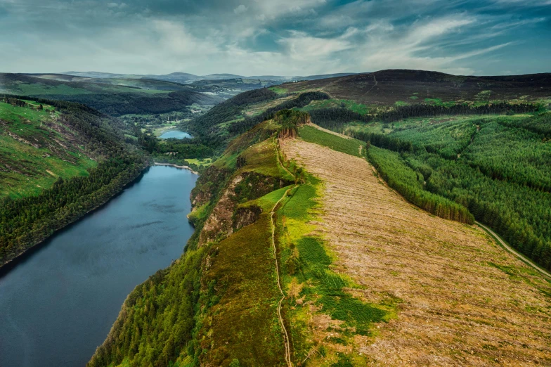 a river running through a lush green valley, by Bedwyr Williams, pexels contest winner, land art, standing on a cliffside, thumbnail, lakes, panels
