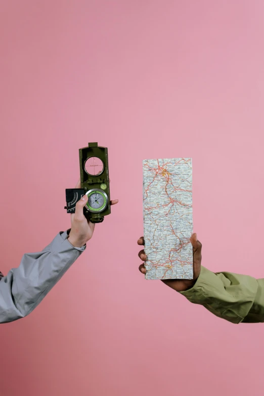 two people holding a map and a compass, inspired by Wes Anderson, trending on unsplash, conceptual art, pink and green, gray men, camo, clemens ascher