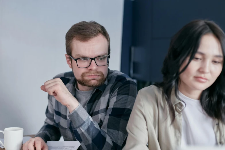 a man and a woman sitting at a table, pexels, angry frown, realistic », nerds, low quality photo
