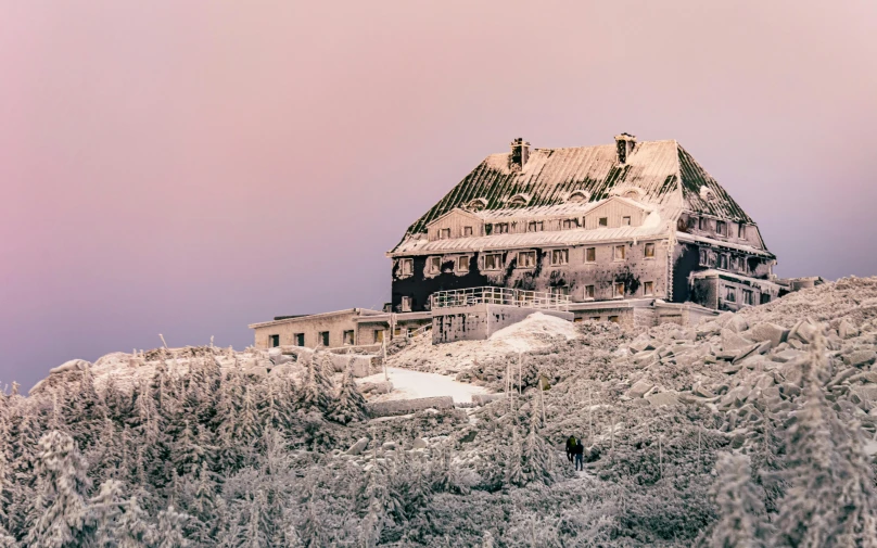 a house sitting on top of a snow covered hill, a colorized photo, inspired by Filip Hodas, unsplash contest winner, art nouveau, the shining overlook hotel, pink, historical photo, deteriorated