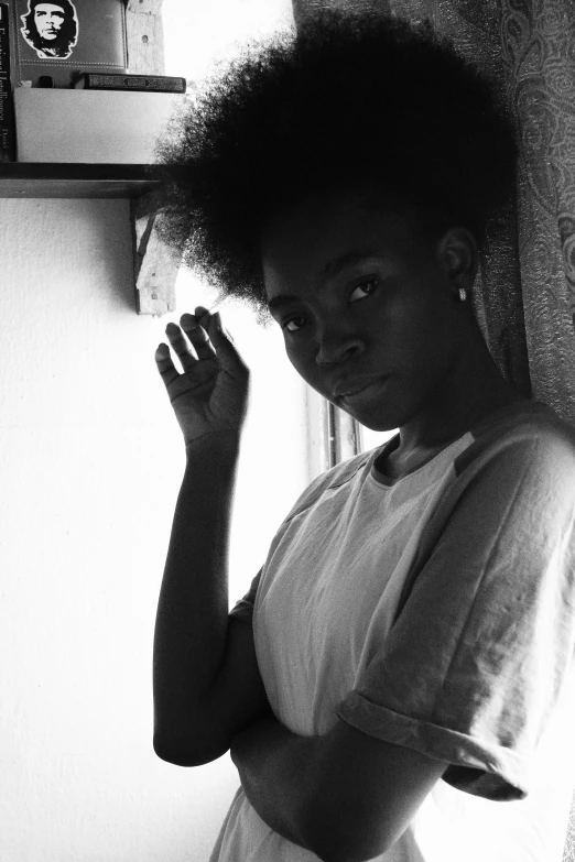 a black and white photo of a woman leaning against a wall, a black and white photo, inspired by Carrie Mae Weems, pexels contest winner, light skinned african young girl, selfie of a young woman, afro samurai style, black teenage girl