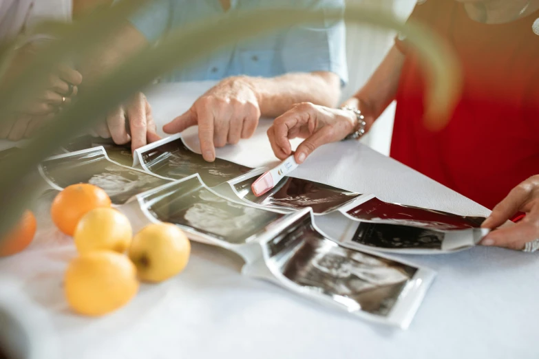 a couple of people that are sitting at a table, pexels contest winner, process art, professional fruit photography, photocopied, album, pregnancy