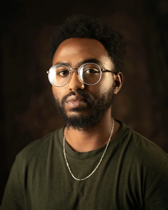 a man with a beard and glasses posing for a picture, an album cover, inspired by Xanthus Russell Smith, trending on unsplash, black arts movement, delicate androgynous prince, non binary model, large friendly eyes, donald glover