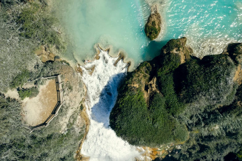 an aerial view of a large body of water, by Daren Bader, pexels contest winner, hurufiyya, next to a waterfall, apulia, abel tasman, kimberly asstyn