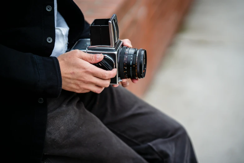 a close up of a person holding a camera, inspired by Vivian Maier, unsplash, hasselblad medium format, highly polished, hasselblad 500c, colour photograph