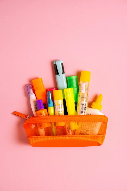 a basket full of pens and pencils on a pink surface, neon orange, pouches, on clear background, ((neon colors))