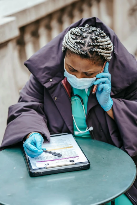 a woman sitting at a table talking on a cell phone, pandemic, healthcare worker, maria borges, charts