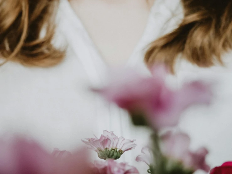 a woman standing in front of a bunch of flowers, trending on pexels, romanticism, white and pink cloth, background image, upclose, wearing a white blouse