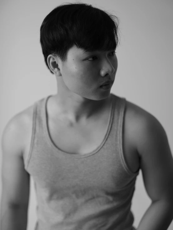 a black and white photo of a man in a tank top, inspired by Joong Keun Lee, unsplash, realism, portrait a 1 5 - year - old boy, genderless, kano tan'yu, androgynous person