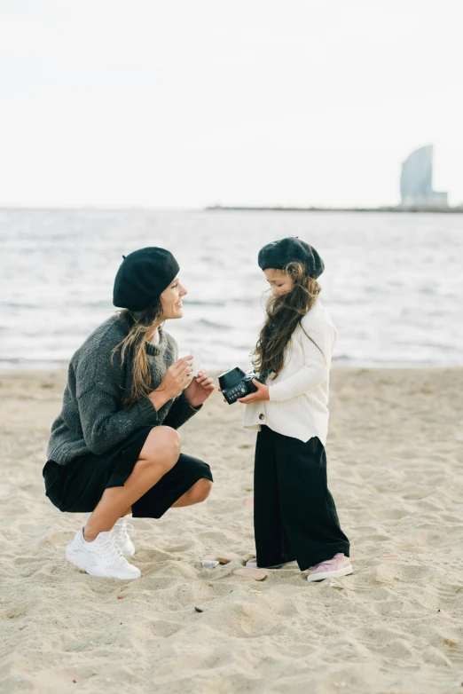 a woman kneeling next to a little girl on a beach, by Lucia Peka, pexels contest winner, man proposing his girlfriend, streetwear, in barcelona, smol