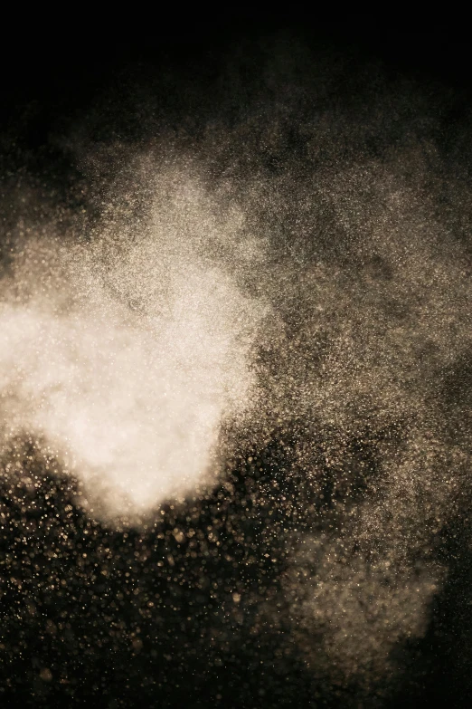 white powder flying in the air on a black background, a stipple, trending on unsplash, kinetic pointillism, sand mists, gold mist, paul barson, dusty old ferrotype