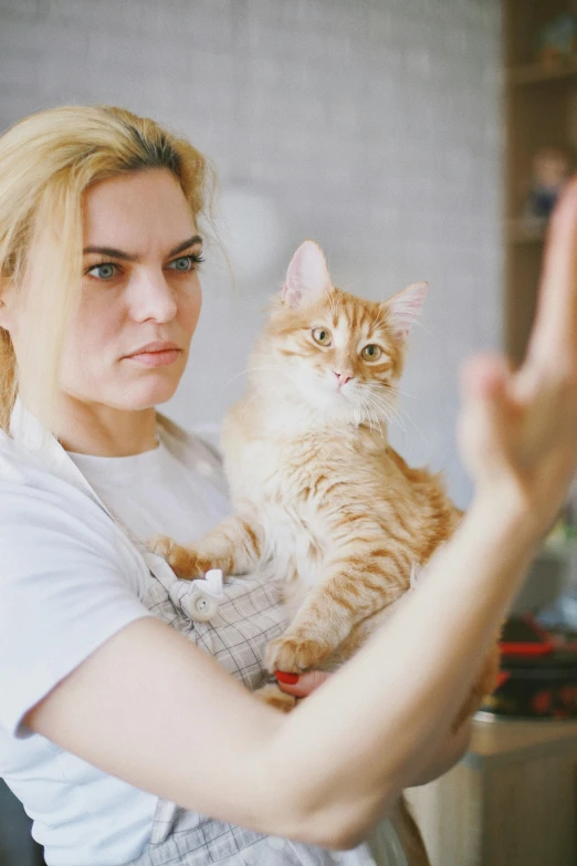 a woman holding a cat in her arms, a picture, shutterstock, angry at mirror, instagram influencer, a blond, hr ginger