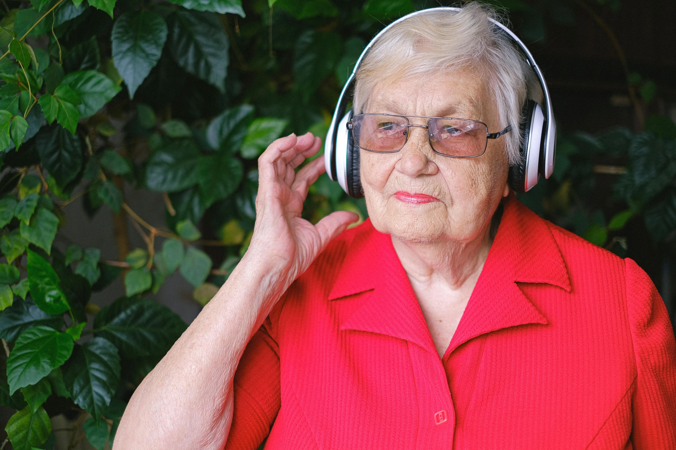 a woman in a red shirt is wearing headphones, by Hazel Armour, pexels, renaissance, nursing home, album cover, music video, no cropping