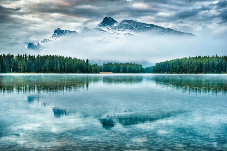 a lake with a mountain in the background, by Erik Pevernagie, pexels contest winner, fan favorite, cyan fog, banff national park, high definition photo