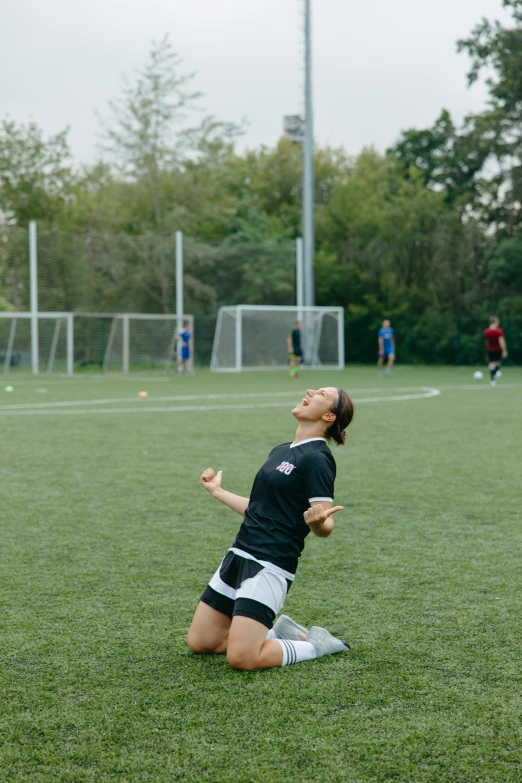 a woman sitting on the ground with a frisbee in her hand, inspired by Christen Dalsgaard, unsplash contest winner, renaissance, on a soccer field, yawning, with arms up, kneeling and looking up