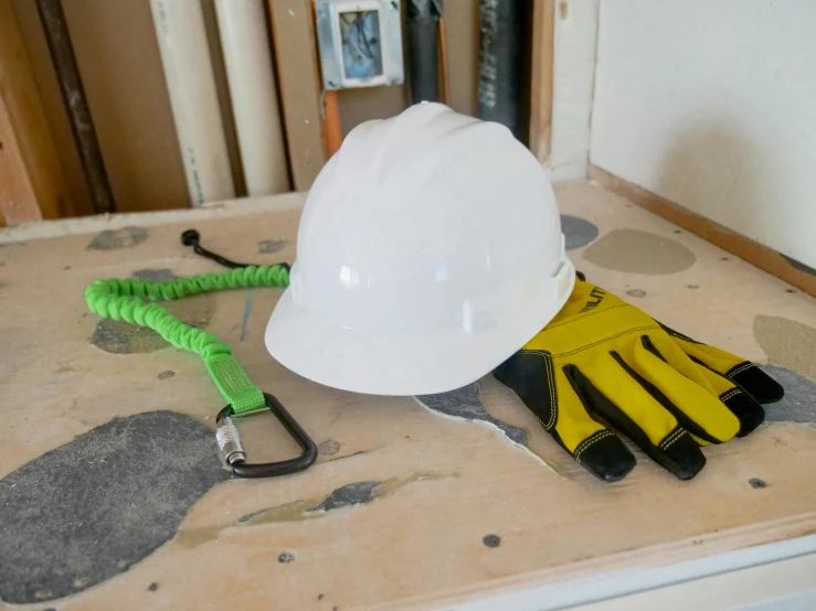 a white hard hat sitting on top of a table, by Bernie D’Andrea, pexels contest winner, yellow latex gloves, a wooden, whitewashed housed, a brightly coloured