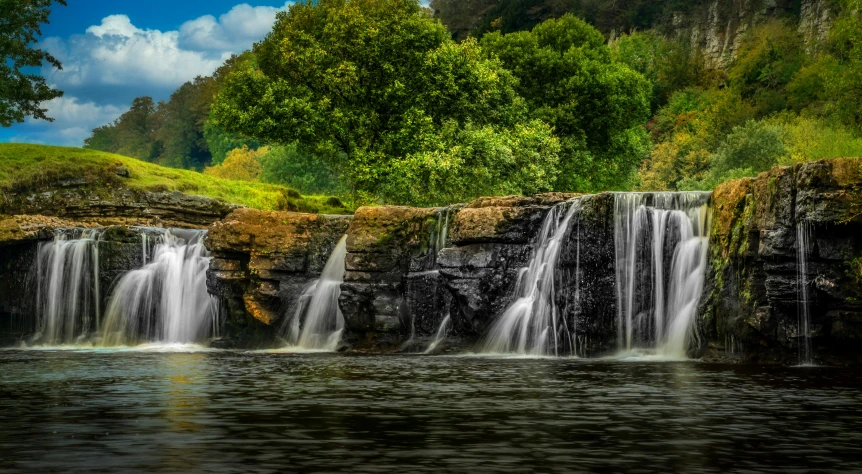 a waterfall in the middle of a lush green forest, by Jesper Knudsen, pexels contest winner, romanticism, river and trees and hills, yorkshire, rocky cliff, water splashes cascades