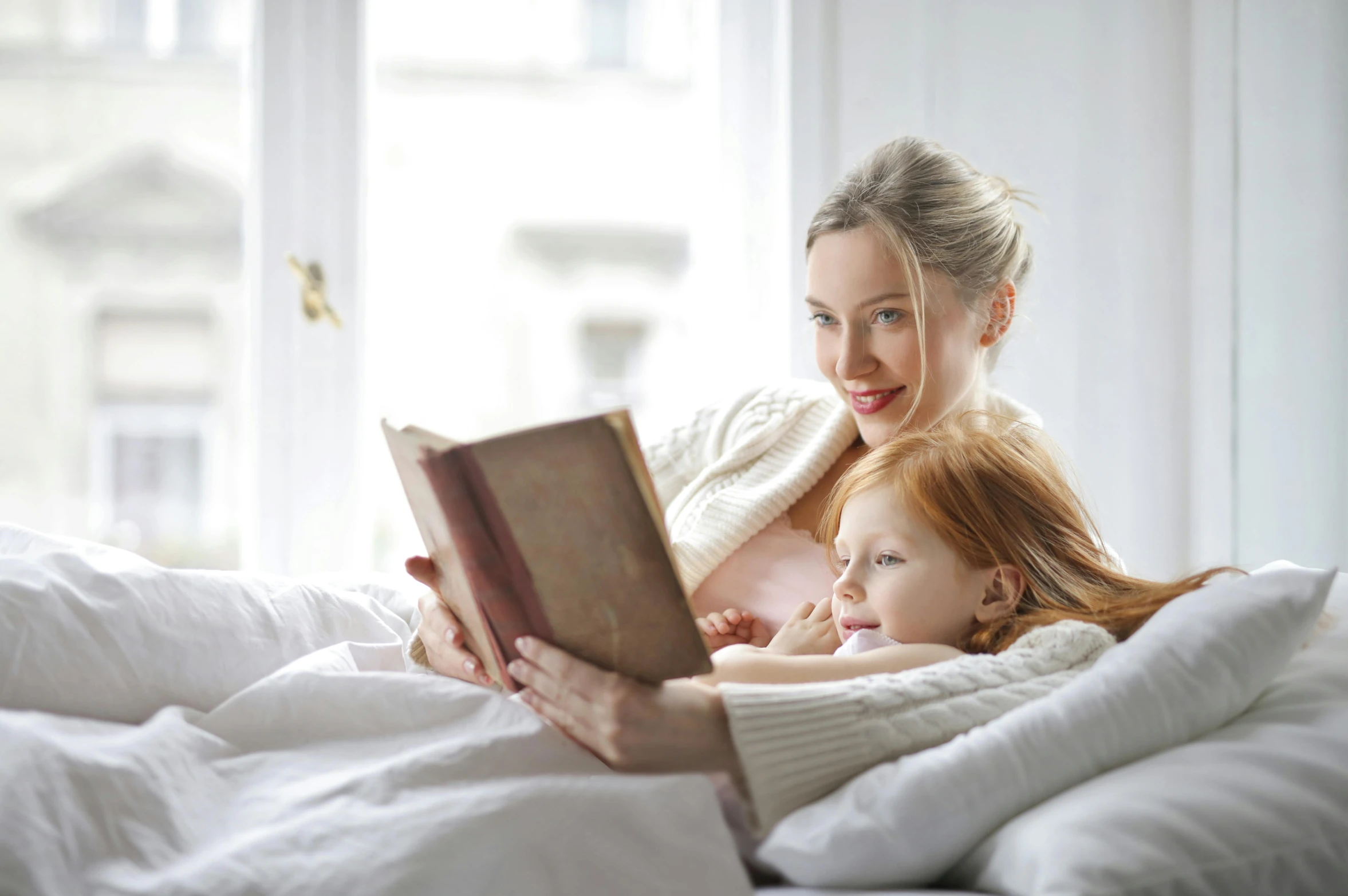 a woman reading a book to a child on a bed, inspired by Elsa Beskow, pexels, avatar image, white, small, beauty shot