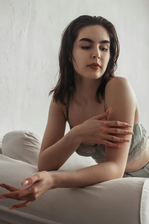 a beautiful young woman laying on top of a bed, a colorized photo, inspired by Elsa Bleda, trending on pexels, skinny upper arms, on a pale background, sitting on couch, gif