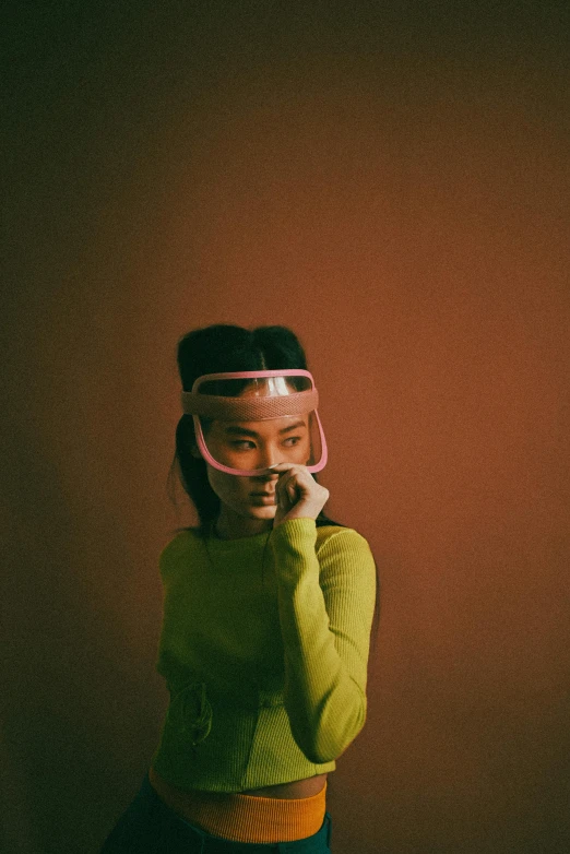 a woman in a green sweater talking on a cell phone, an album cover, by Liam Wong, point of view of visor wearer, pink headband, bella poarch, mask