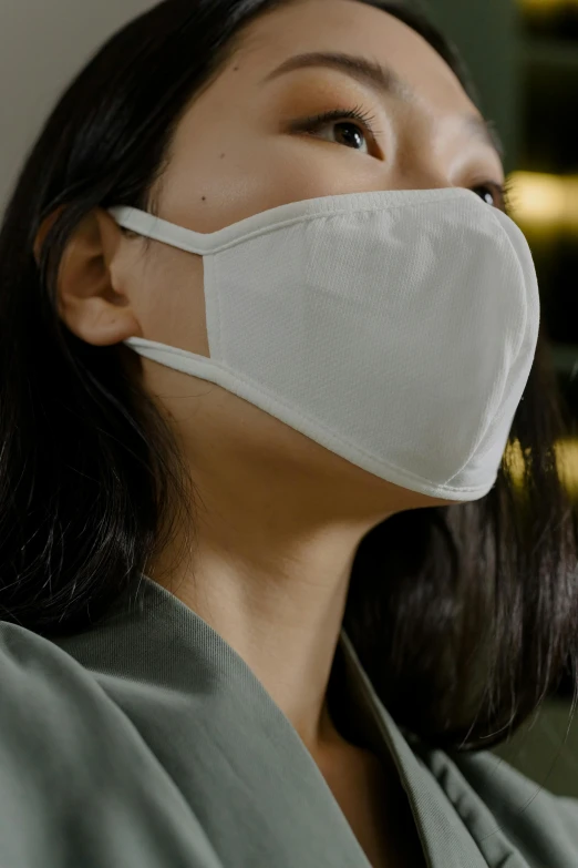 a woman wearing a white face mask, inspired by Kanō Naizen, beige, commercial, grey, jakarta