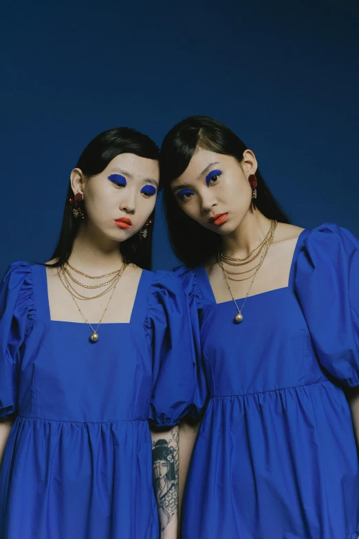 two women in blue dresses standing next to each other, an album cover, inspired by Yves Klein, trending on cg society, aestheticism, big gold eyes, 千 葉 雄 大, siamese twins, profile pic