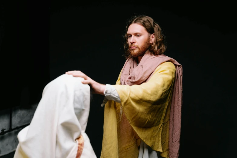 a man standing next to a woman in a white dress, by Everett Warner, trending on unsplash, renaissance, dressed like jesus christ, [ theatrical ], te pae, with yellow cloths