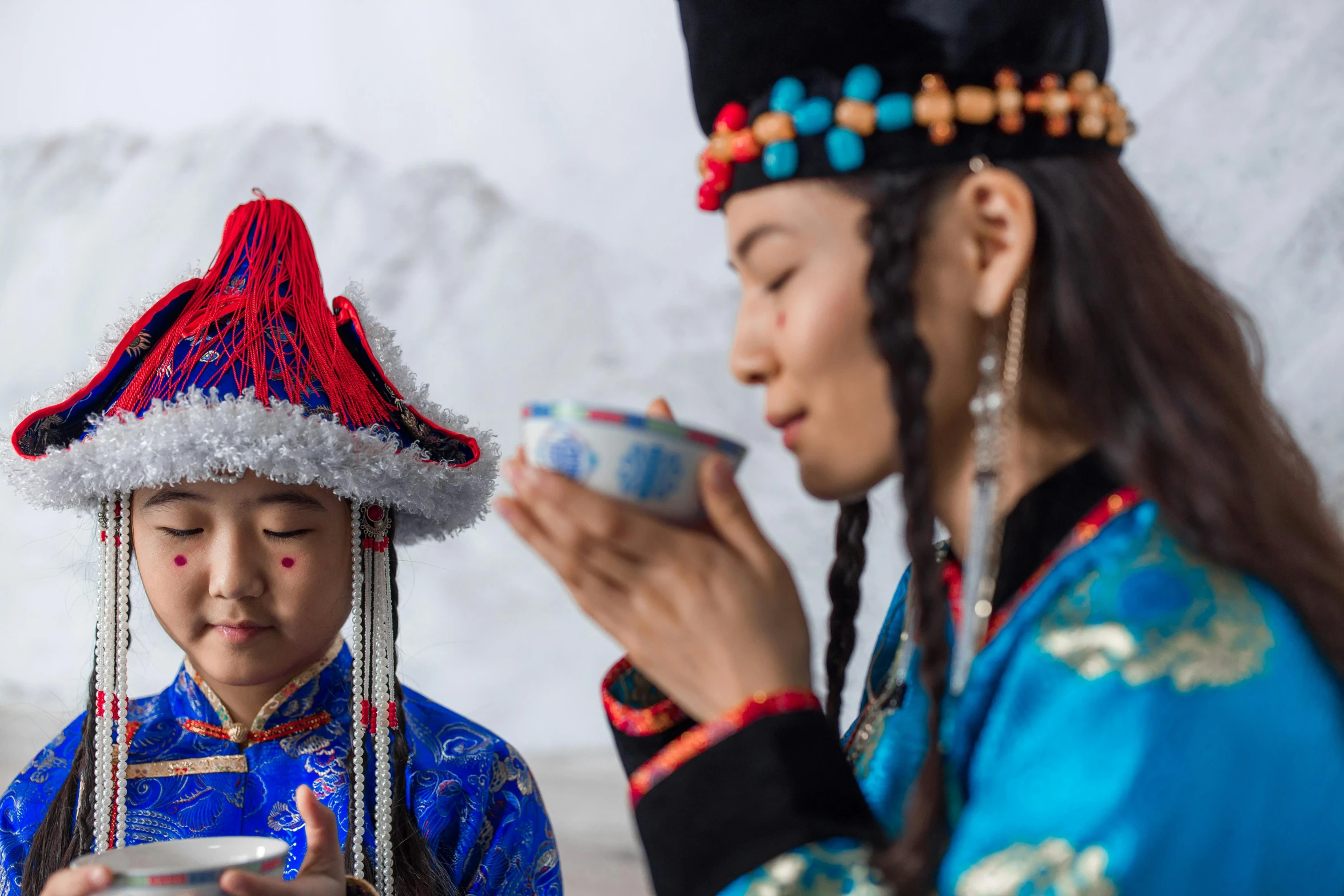 a couple of women standing next to each other, pexels contest winner, cloisonnism, a young female shaman, eating, red and blue garments, 💣 💥💣 💥