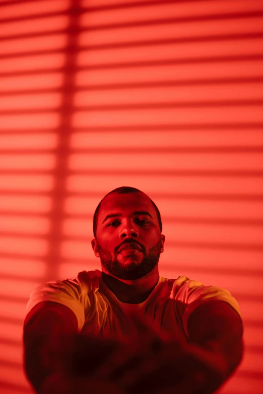 a man standing in front of a red light, sitting down, riyahd cassiem, colors red, drake