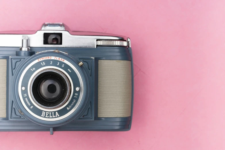 a blue camera sitting on top of a pink surface, inspired by Elsa Bleda, unsplash contest winner, steel gray body, belle, vintage closeup photograph, full face shot