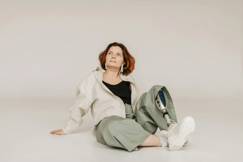 a woman sitting on the floor with a tennis racket, trending on pexels, realism, baggy pants, wearing a flying jacket, white backdrop, a portrait of a plump woman