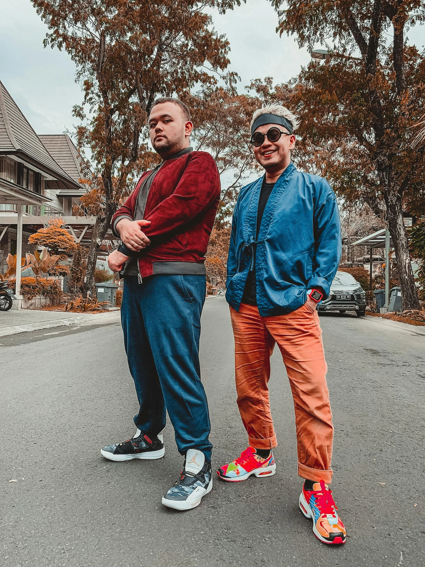 two men standing next to each other on a street, an album cover, inspired by Eddie Mendoza, instagram, dau-al-set, wearing red attire, ( ( ( rainbow ) ) ), wearing a hoodie and sweatpants, birdseye view